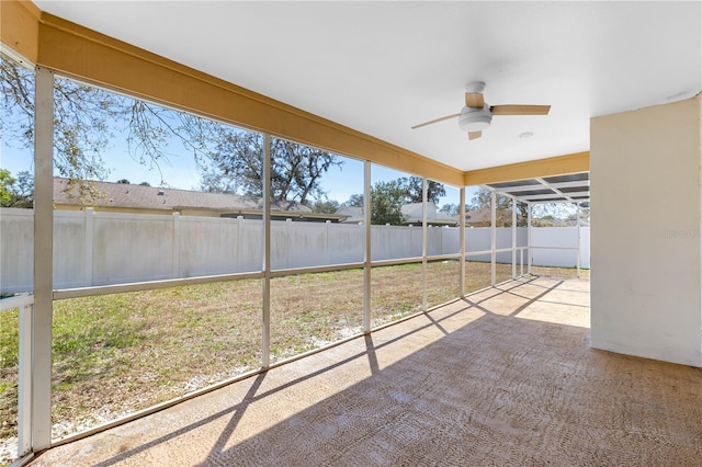 unfurnished sunroom featuring a ceiling fan