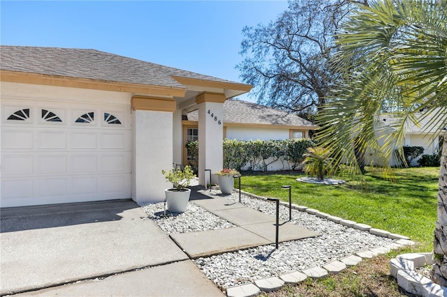 exterior space featuring roof with shingles, a lawn, stucco siding, a garage, and driveway