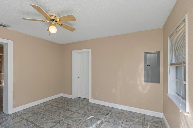 empty room with visible vents, baseboards, electric panel, ceiling fan, and a textured ceiling