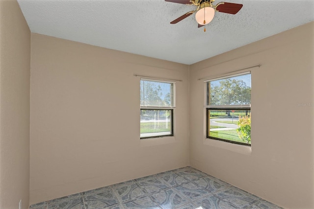 unfurnished room with ceiling fan, a healthy amount of sunlight, and a textured ceiling