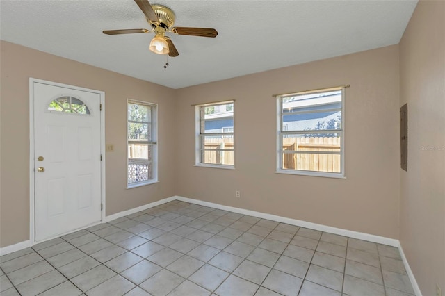 foyer featuring light tile patterned floors, baseboards, and a ceiling fan