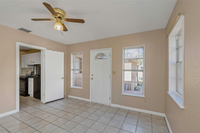 foyer entrance featuring light tile patterned floors, visible vents, a textured ceiling, and a ceiling fan