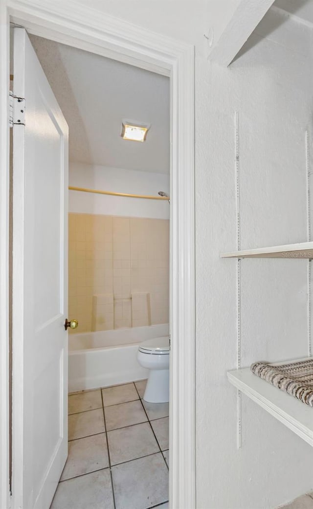 full bathroom featuring tile patterned flooring, toilet, and  shower combination