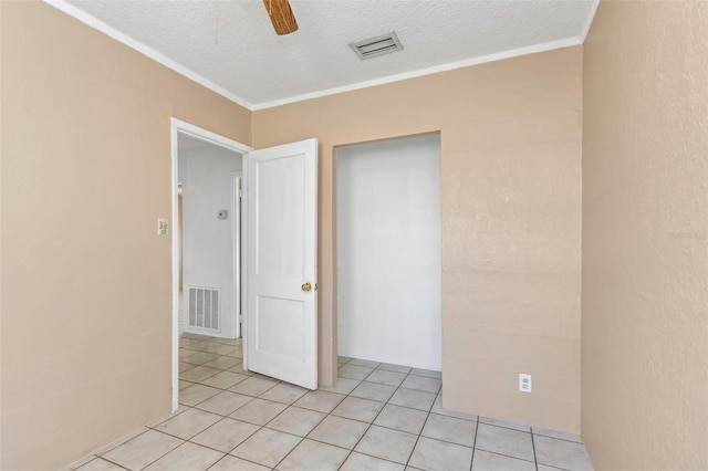 unfurnished room with light tile patterned floors, visible vents, crown molding, and ceiling fan