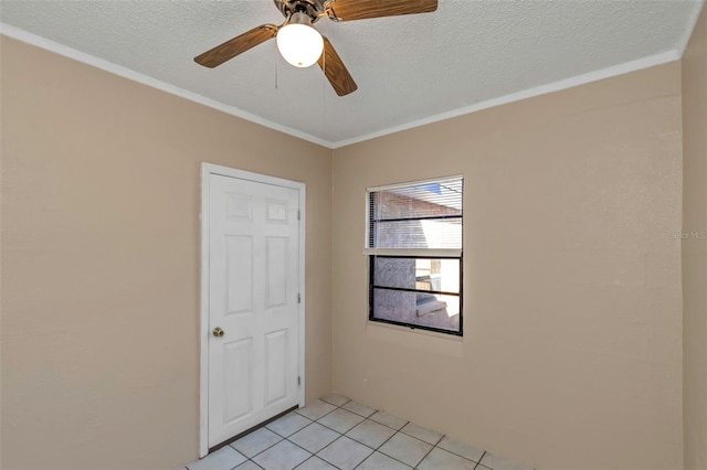 unfurnished room featuring light tile patterned flooring, a textured ceiling, ornamental molding, and a ceiling fan