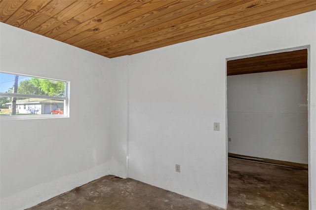 spare room with wooden ceiling and unfinished concrete flooring