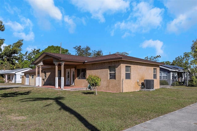 view of front of property with a front yard, central air condition unit, an attached garage, and stucco siding