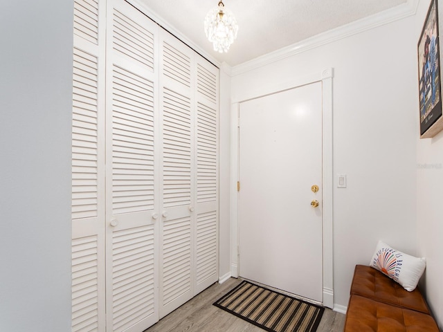 interior space with an inviting chandelier, wood finished floors, and ornamental molding