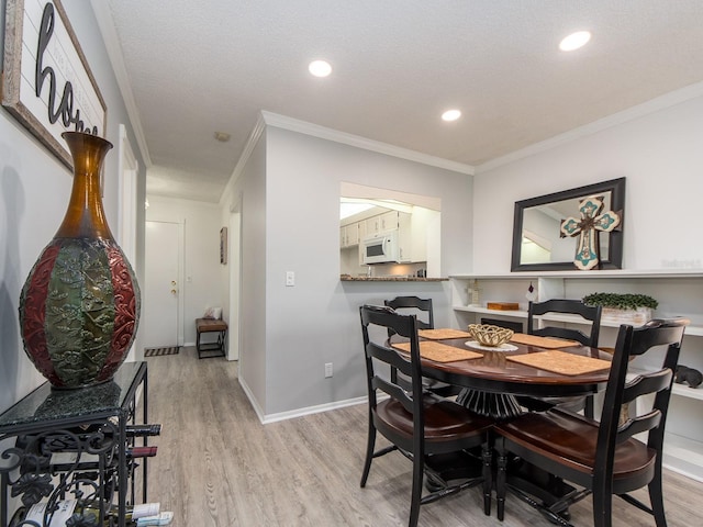 dining area with recessed lighting, baseboards, light wood-style floors, and crown molding