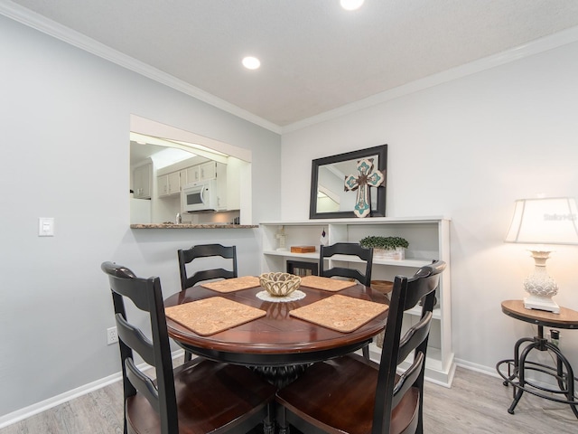 dining space with recessed lighting, light wood-type flooring, baseboards, and ornamental molding