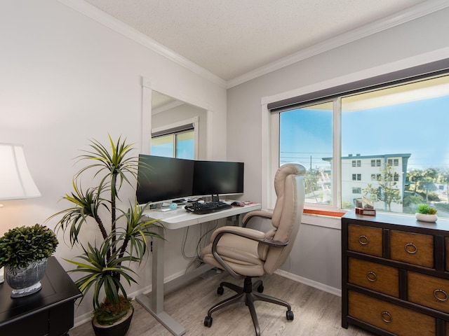 office space with baseboards, a textured ceiling, light wood-style flooring, and ornamental molding