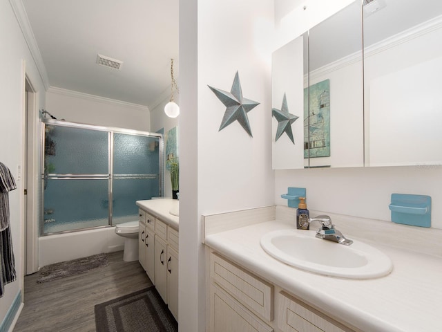 bathroom with visible vents, toilet, ornamental molding, wood finished floors, and vanity