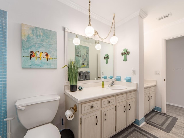 bathroom with vanity, wood finished floors, visible vents, crown molding, and toilet