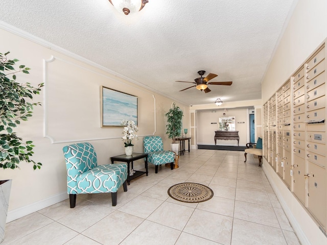 living area with mail area, a textured ceiling, light tile patterned flooring, crown molding, and ceiling fan