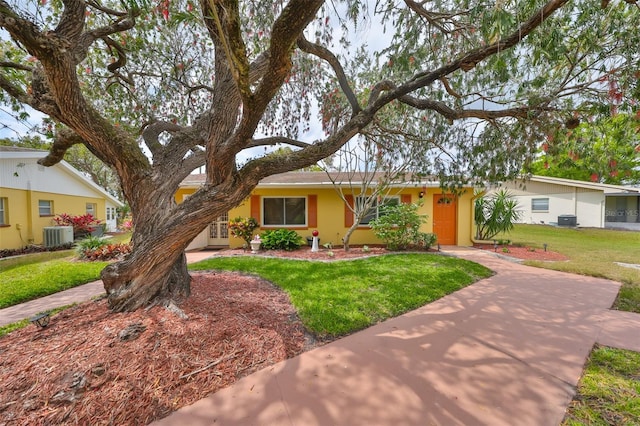 ranch-style house with stucco siding, central AC unit, and a front lawn