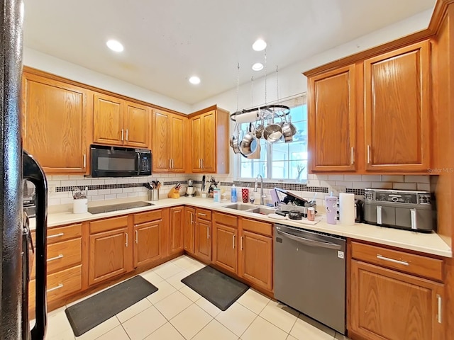 kitchen with black appliances, light countertops, tasteful backsplash, and a sink