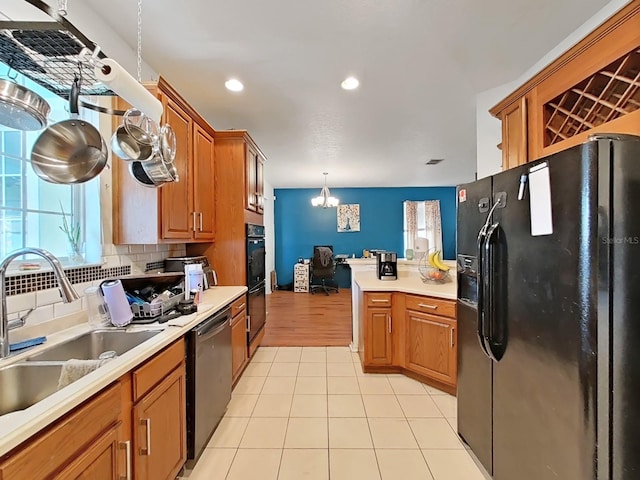 kitchen with black appliances, light countertops, tasteful backsplash, and a sink