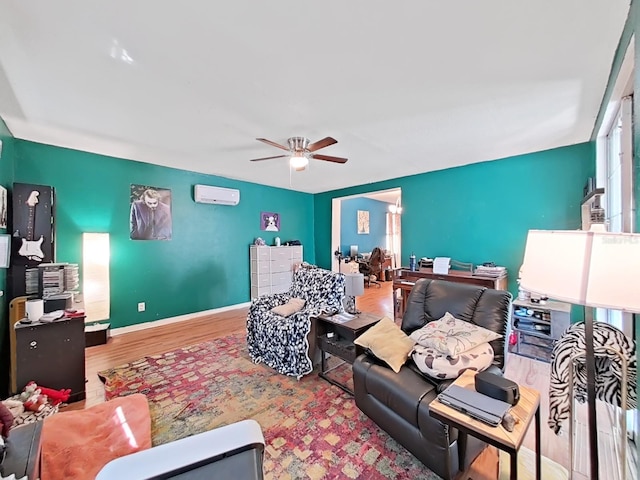 living room featuring ceiling fan, baseboards, a wall unit AC, and wood finished floors