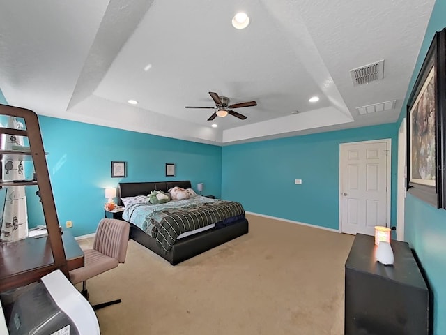 bedroom with visible vents, carpet flooring, a raised ceiling, and baseboards