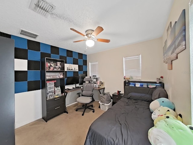 carpeted bedroom featuring wallpapered walls, ceiling fan, visible vents, and a textured ceiling