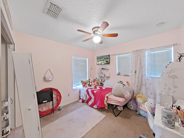 bedroom featuring visible vents, a textured ceiling, concrete floors, and a ceiling fan