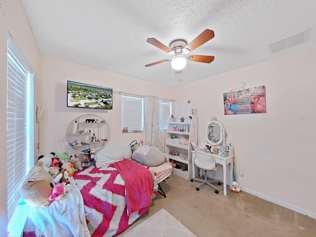 bedroom with visible vents, multiple windows, a textured ceiling, and a ceiling fan