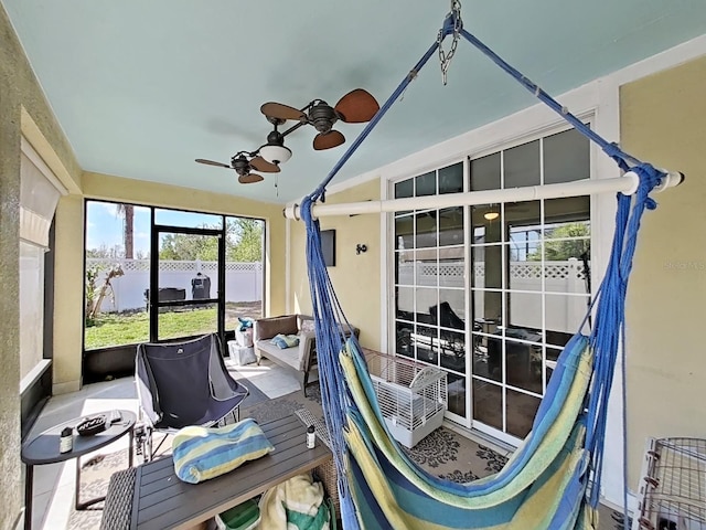 sunroom featuring lofted ceiling and a ceiling fan