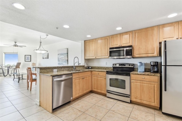 kitchen featuring ceiling fan, light brown cabinetry, a peninsula, stainless steel appliances, and a sink