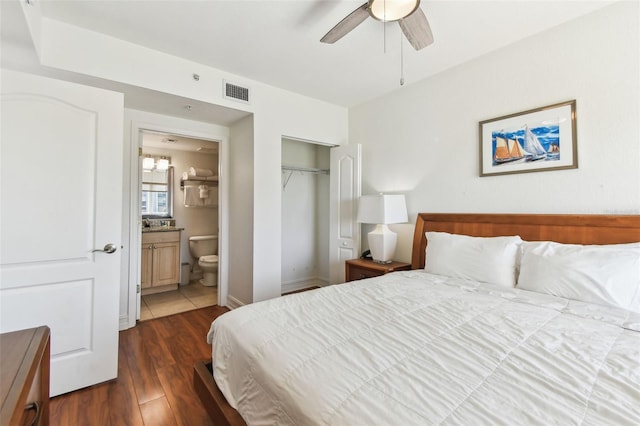 bedroom featuring visible vents, ensuite bath, wood finished floors, a closet, and ceiling fan