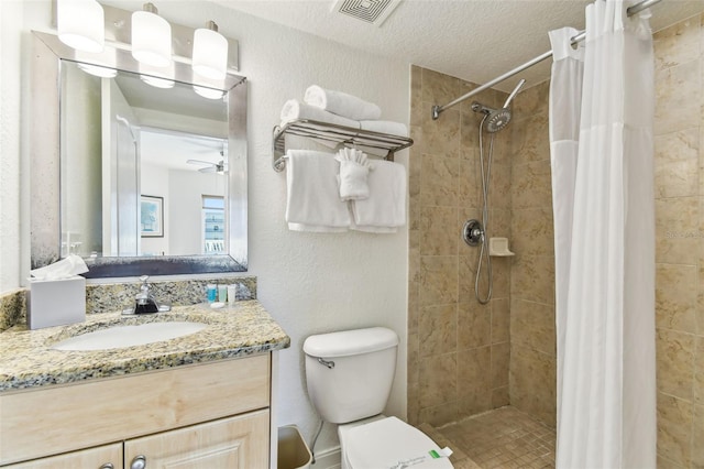 full bathroom featuring vanity, toilet, visible vents, and tiled shower