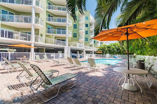 pool with a patio and fence