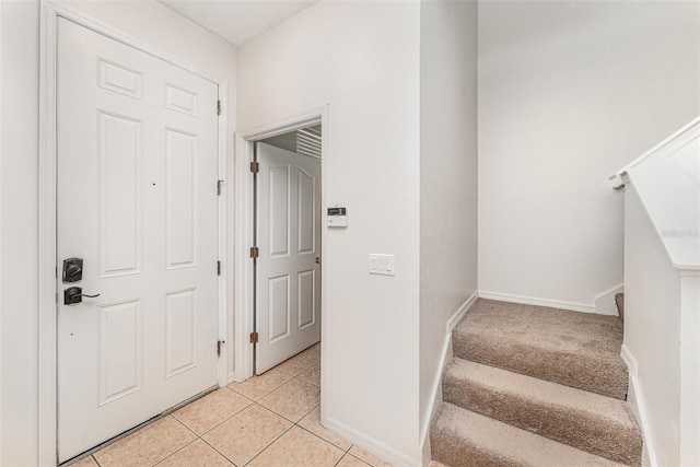 foyer entrance featuring stairway, baseboards, and light tile patterned flooring