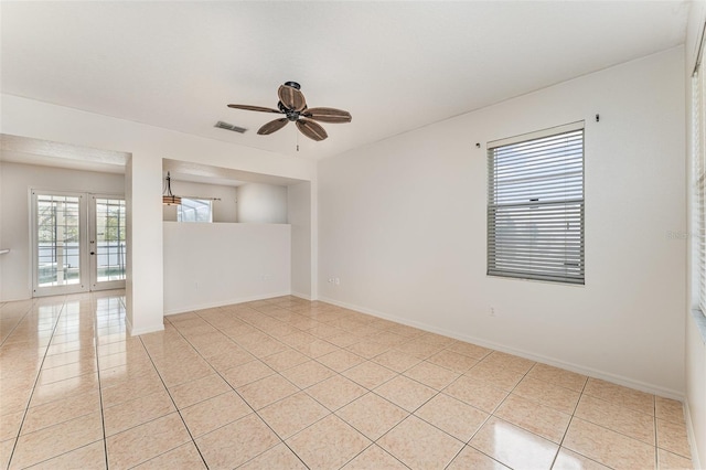 unfurnished room with light tile patterned floors, a ceiling fan, visible vents, baseboards, and french doors