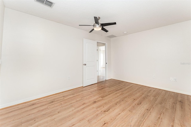 unfurnished room with visible vents, light wood-style flooring, baseboards, and ceiling fan