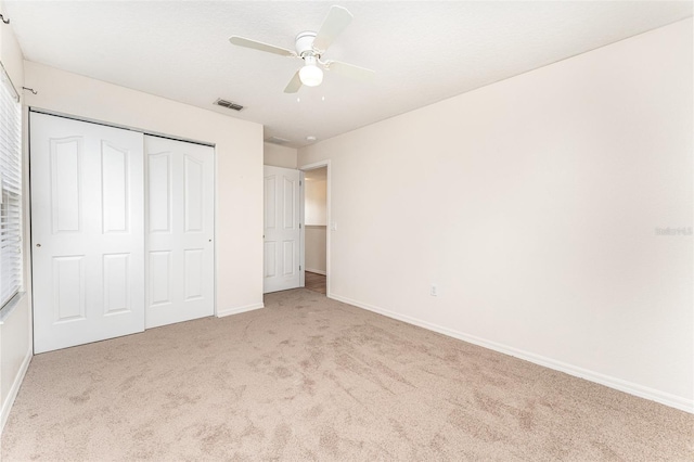 unfurnished bedroom featuring carpet flooring, baseboards, visible vents, and a closet