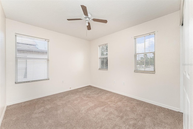 spare room with baseboards, carpet, and ceiling fan