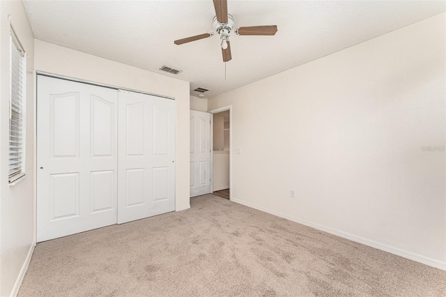 unfurnished bedroom with baseboards, visible vents, carpet floors, and a closet