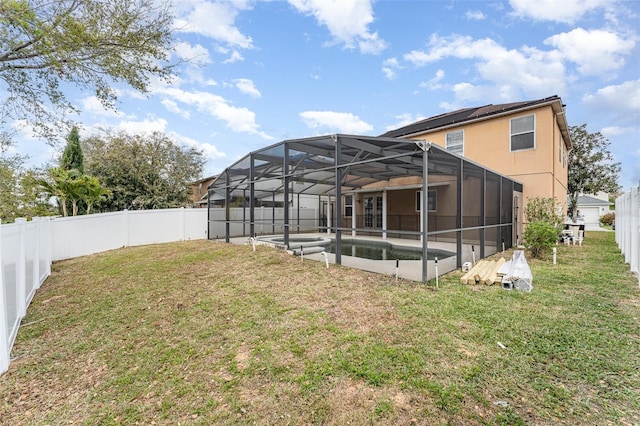 rear view of house featuring a fenced in pool, a lawn, a fenced backyard, and glass enclosure