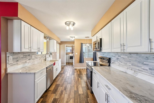 1021 Augusta Dr, Sun City Center, FL 33573 - kitchen with a sink, independent washer and dryer, white cabinetry, and stainless steel appliances