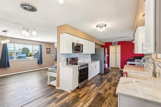 1021 Augusta Dr, Sun City Center, FL 33573 - kitchen with tasteful backsplash, visible vents, stainless steel appliances, white cabinetry, and a sink