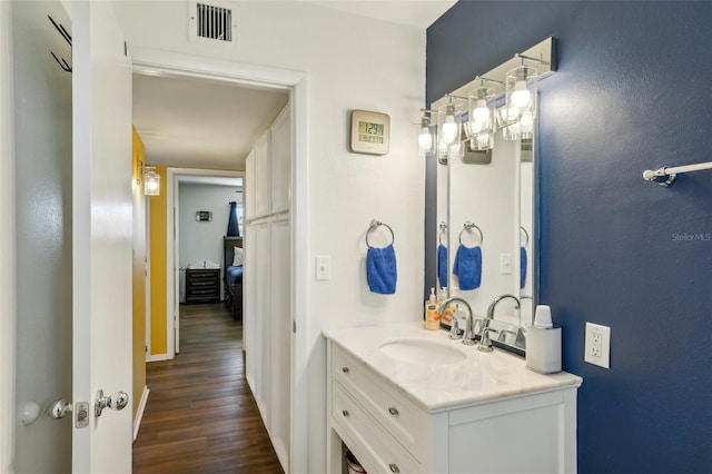 1021 Augusta Dr, Sun City Center, FL 33573 - bathroom featuring vanity, wood finished floors, and visible vents