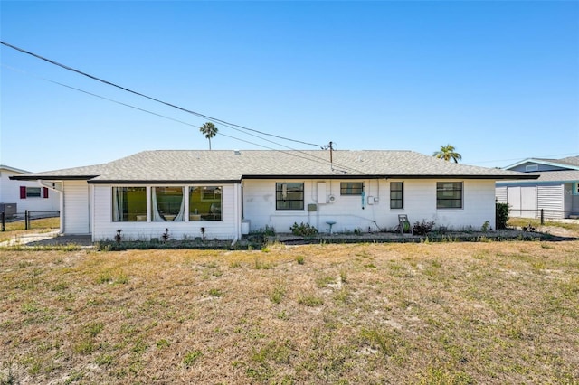 1021 Augusta Dr, Sun City Center, FL 33573 - ranch-style house with roof with shingles, a front yard, and fence