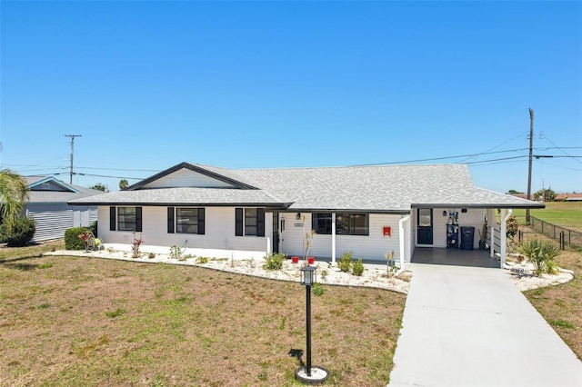 1021 Augusta Dr, Sun City Center, FL 33573 - ranch-style house featuring an attached carport, concrete driveway, a shingled roof, and a front lawn