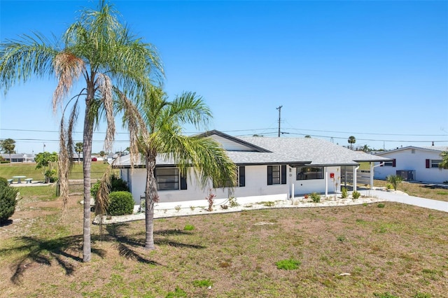 1021 Augusta Dr, Sun City Center, FL 33573 - ranch-style house featuring a front lawn and roof with shingles