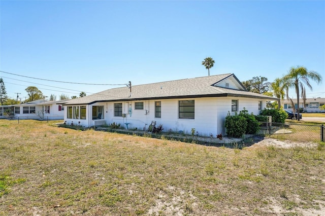 1021 Augusta Dr, Sun City Center, FL 33573 - rear view of property featuring a yard, a shingled roof, and fence