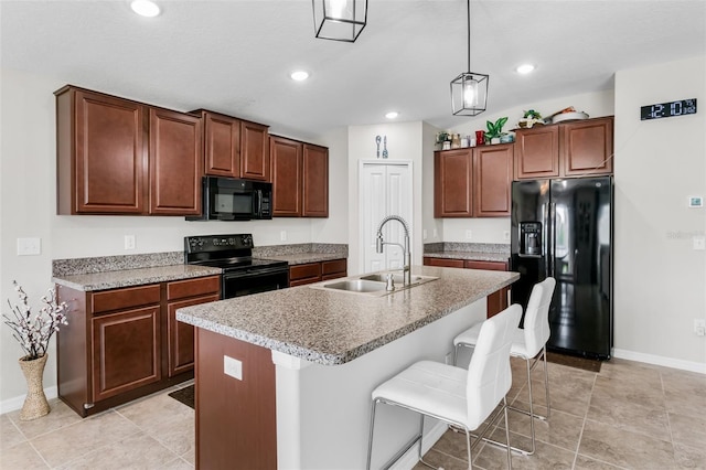 10105 Paradise Fish Dr, Riverview, FL 33578 - kitchen with a breakfast bar, an island with sink, recessed lighting, black appliances, and a sink