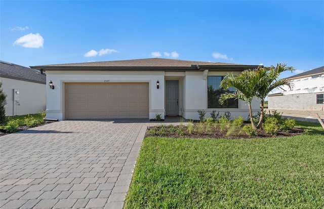 single story home featuring stucco siding, an attached garage, decorative driveway, and a front yard