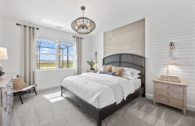 carpeted bedroom with a notable chandelier and baseboards