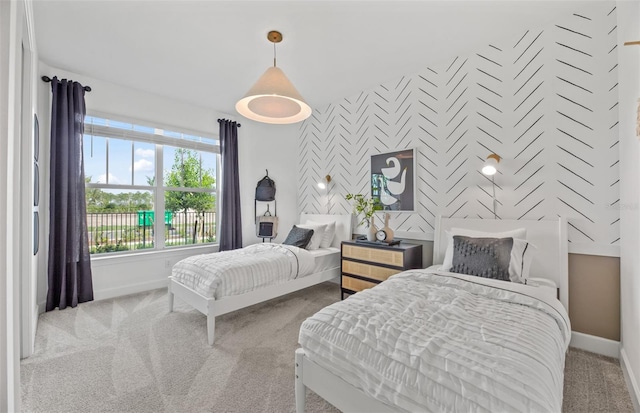 carpeted bedroom with wallpapered walls, an accent wall, and baseboards