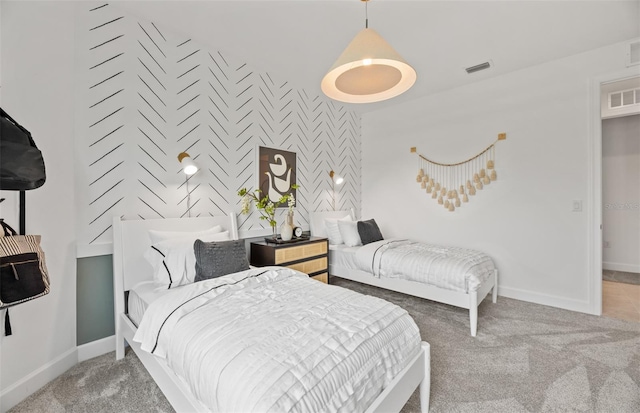 bedroom with an accent wall, carpet, visible vents, and baseboards